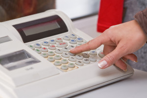 woman pressing button on electronic cash register